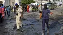 Pasukan keamanan melakukan olah TKP lokasi ledakan bom mobil yang terjadi dekat pos pemeriksaan parlemen dan Kementerian Dalam Negeri di Ibu Kota Somalia, Mogadishu, Minggu (25/3). Tidak ada klaim tanggung jawab atas serangan. (AP/Farah Abdi Warsameh)