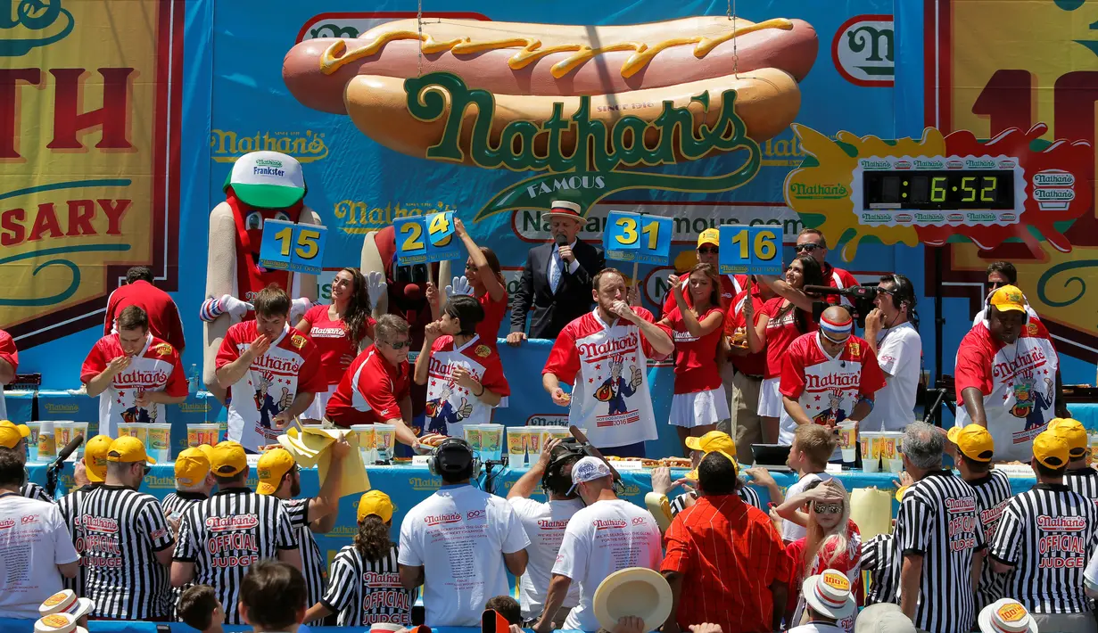 Sejumlah peserta berlomba memakan Hot Dog di Nathan's Famous 4 Fourth of July International Hot Dog-Eating Contest, New York , AS, (4/7).  Salah satu lomba makan Hot Dog terbesar diikuti peserta pria dan wanita. ( REUTERS / Andrew Kelly)