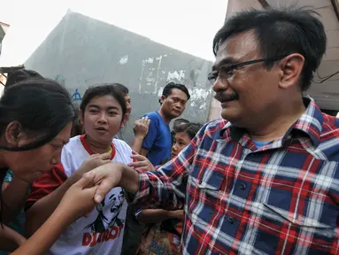 Warga berjabat tangan dengan Cawagub DKI Jakarta, Djarot Saiful Hidayat di Tegal Alur, Jakarta, Rabu (7/12). Dalam blusukannya Djarot berjanji akan segera memasukkan pelayanan air perpipaan di permukiman warga Tegal Alur. (Liputan6.com/Yoppy Renato)