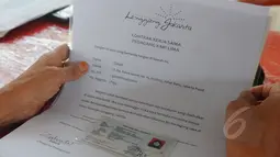 Seorang pedagang melihat surat kontrak kerja sama saat pembuatan tanda pengenal di Kawasan Lenggang Jakarta, Monumen Nasional, Jakarta, Rabu (8/4/2015). (Liputan6.com/Herman Zakharia) 