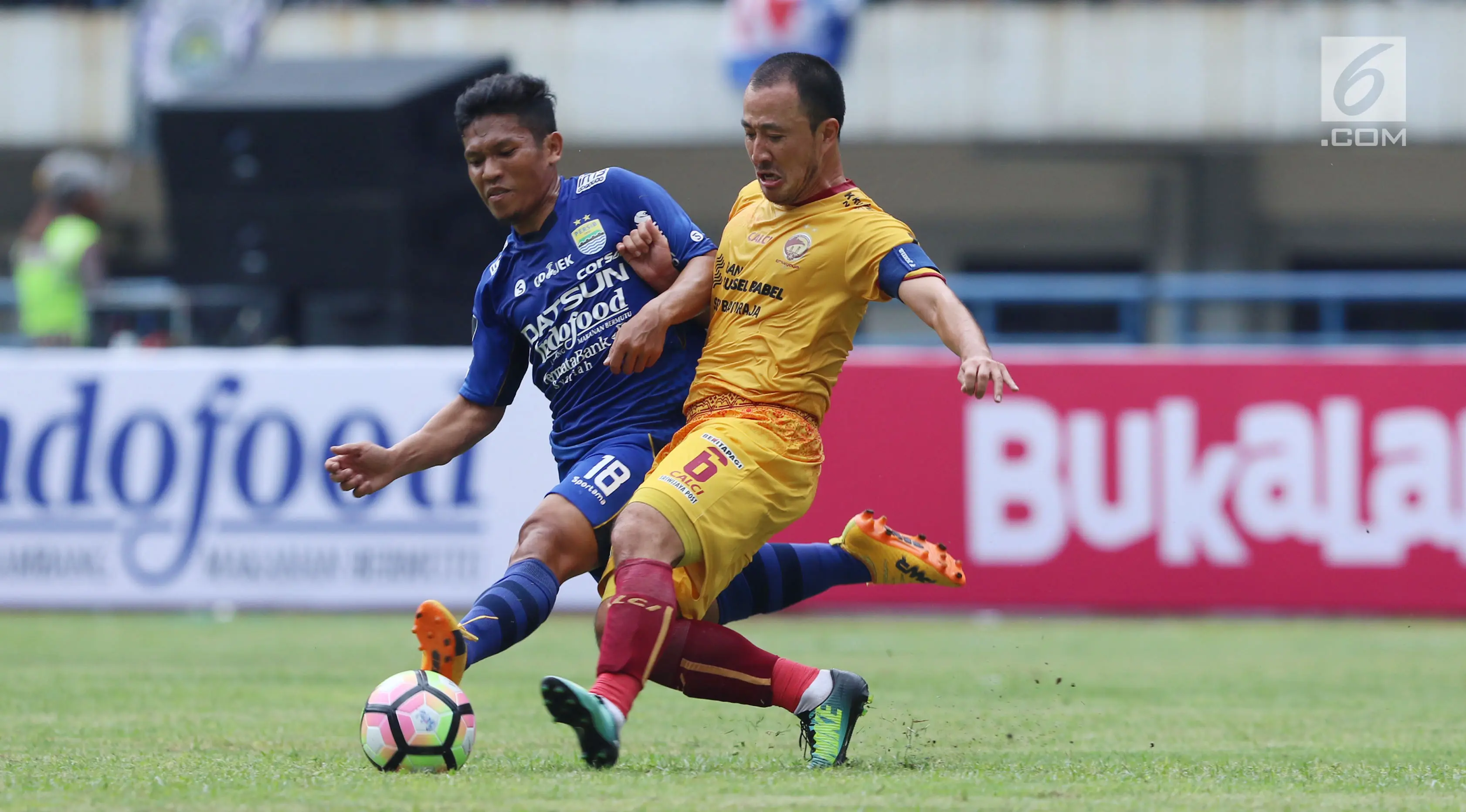 Gelandang Persib, Eka Ramdhani (kiri) berebut bola dengan pemain Sriwijaya FC, Yu Hyunk Doo pada laga pembuka Piala Presiden 2018 di Stadion GBLA, Bandung, Selasa (16/1). Persib unggul 1-0. (Liputan6.com/Helmi Fithriansyah)