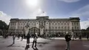Turis berdiri di depan Istana Buckingham di London, Kamis (8/9/2022).  Istana Buckingham mengatakan Ratu Elizabeth II telah ditempatkan di bawah pengawasan medis karena dokter "memperhatikan kesehatan Yang Mulia." Anggota keluarga kerajaan pergi ke Skotlandia untuk bersama raja berusia 96 tahun itu. (AP Photo/Frank Augstein)