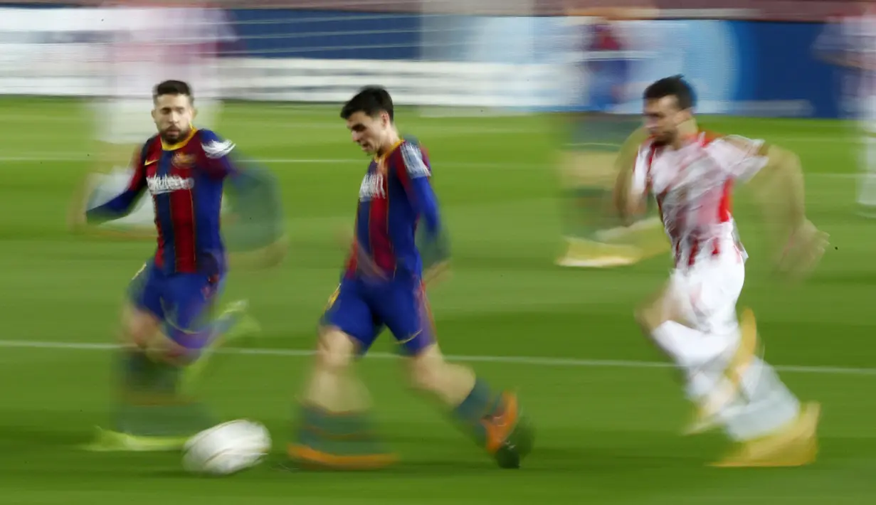 Foto yang diambil dengan kecepatan rana lambat, bek dan penyerang Barcelona Jordi Alba dan Pedri berlari saat menantang Athletic Bilbao pada pekan ke-21 Liga Spanyol 2020/21 di Stadion Camp Nou, Senin (1/2/2021) dini hari WIB. Barcelona sukses mengalahkan Athletic Bilbao 2-1. (AP Photo/Joan Monfort)