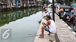 Sejumlah Warga saat memancing ikan di Kali Tanjung Selor, Jakarta, Rabu (20/1). Meskipun keruh dan dipenuhi sampah, namun Kali Tanjung Selor menjadi lokasi favorit bagi warga sekitar untuk memancing dengan biaya murah. (Liputan6.com/Immanuel Antonius)