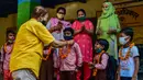 Guru menyambut siswa dengan karangan bunga di sebuah sekolah di Allahabad, India, Rabu (1/9/2021). Pemerintah negara bagian melonggarkan lockdown COVID-19 untuk lembaga pendidikan yang memungkinkan siswa menghadiri sekolah tatap muka dengan 50 persen kapasitas. (SANJAY KANOJIA/AFP)