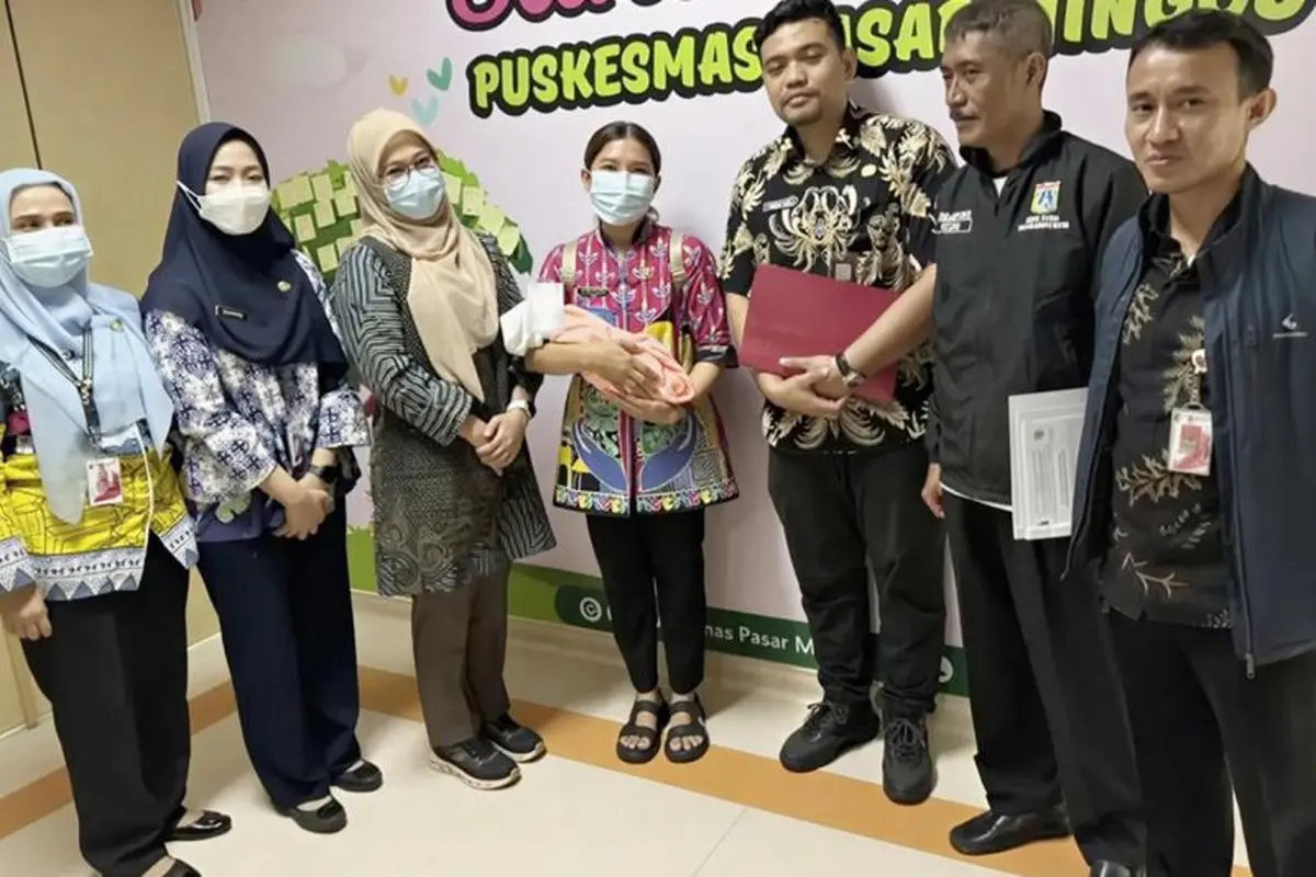 Petugas menggendong bayi laki-laki ditemukan oleh seorang guru bernama Maryono (44) yang tiba di depan SD Tarakanita I, Kebayoran Baru