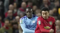 Penyerang Manchester United, Jesse Lingard membawa bola dari kejaran Bek Manchester City, Benjamin Mendy pada pertandingan leg pertama semifinal Piala Liga Inggris di Old Trafford (7/1/2020). City menang 3-1 atas MU. (AP Photo / Jon Super)