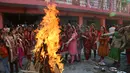 Gadis-gadis India melempar kacang ke api unggun saat mereka merayakan festival Lohri di Jammu, India 13/1). Festival Lohri ini banyak dirayakan oleh orang-orang dari wilayah Punjab di Asia Selatan. (AP Photo / Channi Anand)