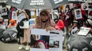 Seorang pekerja rumah tangga (PRT) saat menggelar aksi di depan Taman Aspirasi Monas, Jakarta, Rabu (21/12/2022). Aksi tersebut dilakukan untuk memperingati Hari Ibu serta meminta pemerintah untuk mengesahkan Rancangan Undang-Undang Perlindungan Pekerja Rumah Tangga (RUU PPRT). (Liputan6.com/Faizal Fanani)