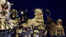 Penari topeng melakukan ritual kuno mengusir roh jahat di jalan-jalan Batanovci, Bulgaria, Kamis malam (13/1/2022). Setiap musim dingin di desa-desa seluruh negara Balkan, pria, wanita dan anak-anak mengenakan topeng ritual dan kostum melakukan tarian di sekitar api unggun. (AP/Valentina Petrova)