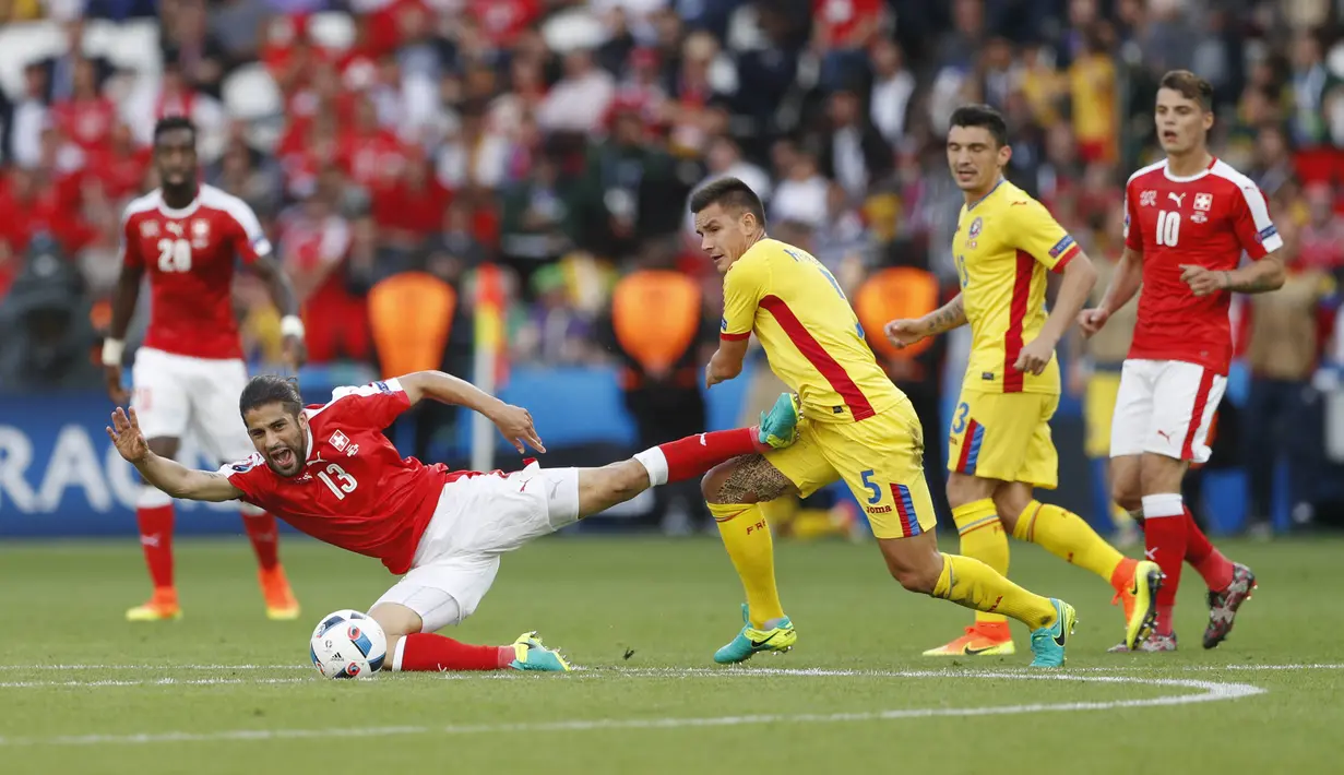 Pemain Swiss, Ricardo Rodriguez (kiri) terjatuh saat berebut bola dengan pemain Rumania, Ovidiu Hoban pada laga Grup A Piala Eropa 2016 di Parc des Princes, Paris, Rabu (15/6/2016) WIB. (REUTERS/John Sibley)