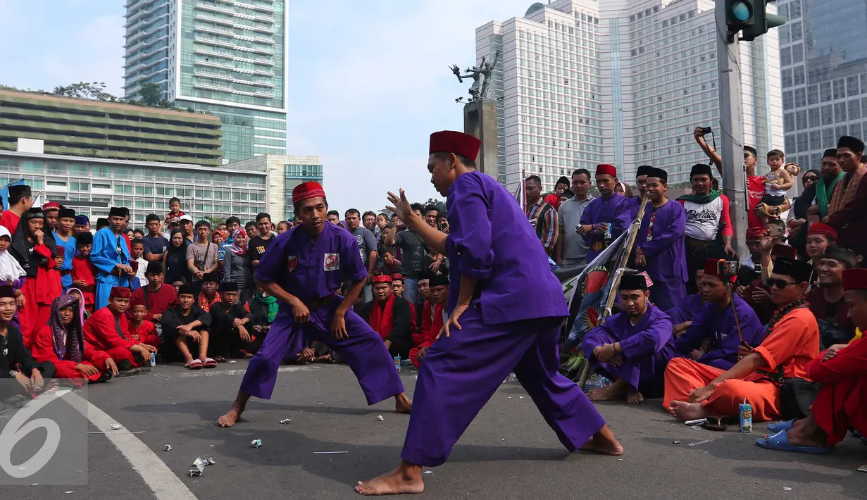 Para pendekar Betawi menunjukan aksi beladiri khas Betawi di Jakarta, Minggu (7/8). Sekitar 1000 pendekar memadati Bundaran HI untuk merayakan Lebaran Pendekar Betawi 2016. (Liputan6.com/Angga Yuniar)