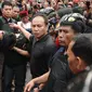 Petugas kepolisian menggiring salah satu tersangka perampokan disertai penyanderaan di Kawasan Pondok Indah, Jakarta, Minggu (3/9). Perampokan disertai penyanderaan terjadi sejak Minggu (3/9) pagi. (Liputan6.com/Helmi Fithriansyah)