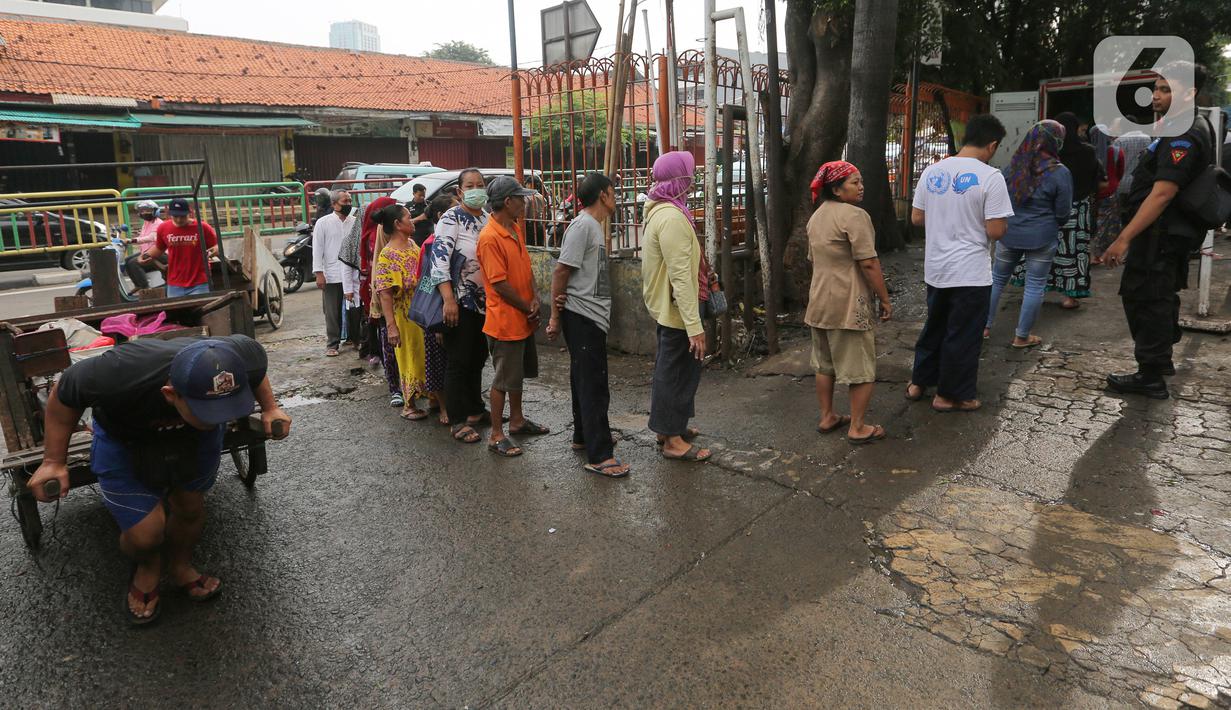 Warga antre saat Operasi Pasar di Pasar Palmerah, Jakarta, Jumat (20/3/2020). Perum Bulog bekerja sama dengan Sugar Group Companies menyiapkan 10 ton suplai gula tiap harinya dalam rangka Gerakan Stabilitas Pangan di 35 titik pasar. (Liputan6.com/Fery Pradolo)