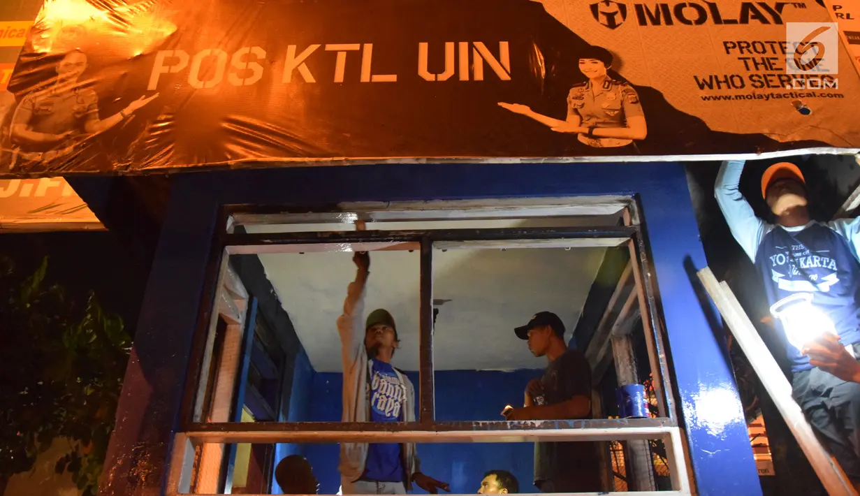 Petugas dan warga memperbaiki pos polisi yang sebelumnya dibakar massa saat peringatan Hari Buruh di Yogyakarta, Selasa (1/5) malam. Hari Buruh di Yogyakarta diwarnai aksi bakar pos polisi di pertigaan kampus UIN Sunan Kalijaga. (Liputan6.com/Gholib)