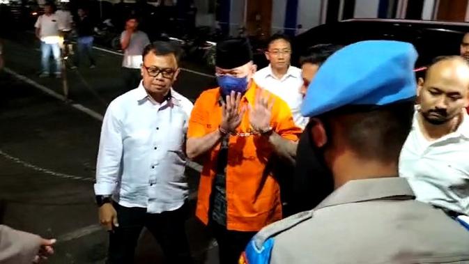 Penampakan mantan Kapolda Sumbar Irjen Teddy Minahasa memakai baju tahanan berwarna oranye dengan tangan diborgol saat dijebloskan ke Rutan Polda Metro Jaya. (Merdeka.com)