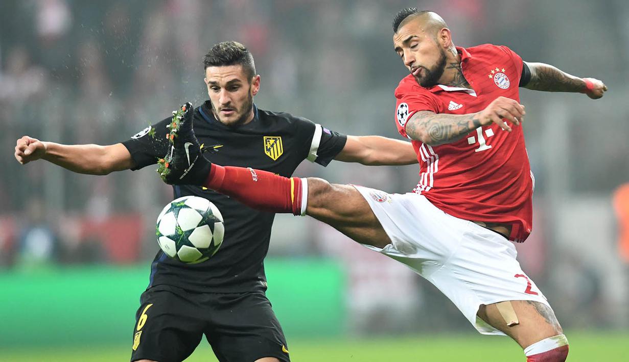 Gelandang Bayern Munchen, Arturo Vidal, berebut bola dengan gelandang Atletico Madrid, Koke. Namun kemenangan ini tidak mampu membuat Munchen menggusur posisi Atletico di puncak klasemen Grup D. (AFP/Peter Kneffel)
