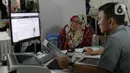 Petugas melayani pembuatan paspor salah satu warga saat berlangsungnya Immigration Servis pada hari bebas kendaraan bermotor di kawasan Plaza Parkir Timur Gelora Bung Karno, Jakarta, Minggu (28/1/2024). (Liputan6.com/Herman Zakharia)