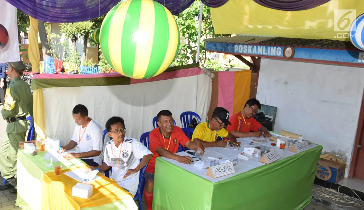 Petugas KPPS menggunakan jersey negara peserta Piala Dunia pada Pilkada Serentak 2018 di TPS 7 Kelurahan Bulu Lor, Semarang. Rabu (27/6). Konsep Piala Dunia tak hanya jersey tapi diikuti ornamen dan bendera dari perwakilan negara. (Liputan6.com/Gholib)