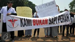 Puluhan dokter dari Pergerakan Dokter Muda Indonesia (PDMI) melakukan unjuk rasa di depan Istana Merdeka, Jakarta, Senin (7/9). Mereka  memprotes penyelenggaraan ujian kompetensi di berbagai universitas yang ada di Indonesia. (Liputan6.com/Gempur M Surya)