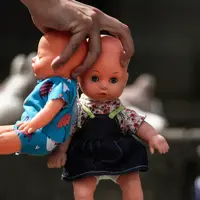 Seseorang meletakkan boneka mainan di halaman gedung Kongres Kolombia untuk memprotes kekerasan seksual terhadap anak di Bogota, Selasa (20/11). Protes ini untuk meningkatkan kesadaran tentang tanggung jawab perlindungan anak-anak. (DANIEL MUNOZ/AFP)