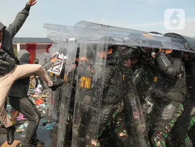 Tentara Nasional Indonesia (TNI) melakukan simulasi demonstrasi pengerahan massa yang anarkis pada Apel Pengamanan Pemilu 2024 di Lapangan Halim Perdanakusuma, Jakarta, Kamis (1/2/2024). (merdeka.com/Imam Buhori)