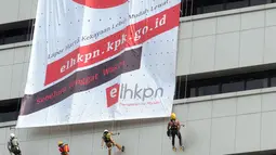 Aktivis membentangkan spanduk raksasa dengan cara repling turun dari gedung C Komisi Pemberantasan Korupsi (KPK) di Jakarta, Senin (26/3). (Merdeka.com/Dwi Narwoko)