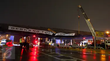 Petugas memperbaiki atap gardu tol yang ambruk di pintu Gardu Tol Cikunir 2, Bekasi, Minggu (14/2). Atap pintu gardu tol tersebut ambruk akibat diterjang hujan disertai angin kencang yang melanda wilayah Bekasi dan sekitarnya (Liputan6.com/Gempur M Surya)