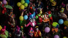 Orang-orang yang mengenakan pakaian badut ikut serta dalam parade badut tahunan di Sesimbra, Portugal pada Senin (4/3/2019). Perayaan ini dilakukan setiap tahun dan jatuh pada hari Senin. (PATRICIA DE MELO MOREIRA / AFP)