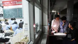 Guru berjaga saat para siswa mengerjakan soal menjelang ujian tahunan "Gaokao" atau ujian masuk perguruan tinggi di China, di Handan di provinsi Hebei Utara (23/5). Gaokao China akan berlangsung 7-8 Juni tahun ini. (AFP Photo/China Out)