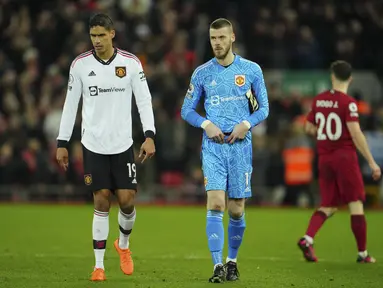 Kiper Manchester United, David de Gea dan bek Raphael Varane meninggalkan lapangan setelah pertandingan melawan Liverpool pada pertandingan lanjutan Liga Inggris di stadion Anfield, Inggris, Minggu (5/3/2023). Liverpool memenangkan pertandingan melawan Manchester United dengan skor telak 7-0. (AP Photo/Jon Super)