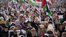 Massa meneriakkan slogan-slogan dan mengibarkan bendera Palestina saat aksi bela Palestina, di Monumen Nasional atau Monas, Jakarta Pusat, Minggu (5/11/2023). (AP Photo/Dita Alangkara)