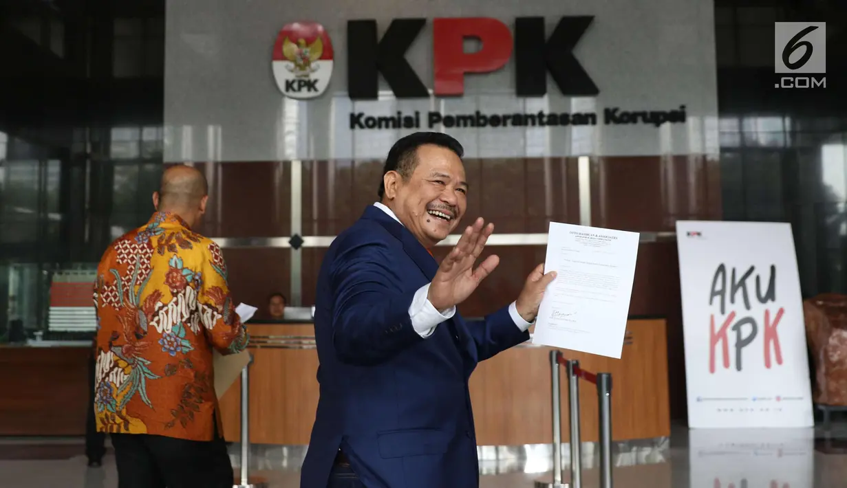 Pengacara Otto Hasibuan menyapa awak media saat tiba di gedung KPK, Jakarta, Jumat (8/12). Kedatangan Otto ke KPK untuk memberikan surat keterangan pengunduran dirinya sebagai kuasa hukum Setya Novanto. (Liputan6.com/Angga Yuniar)