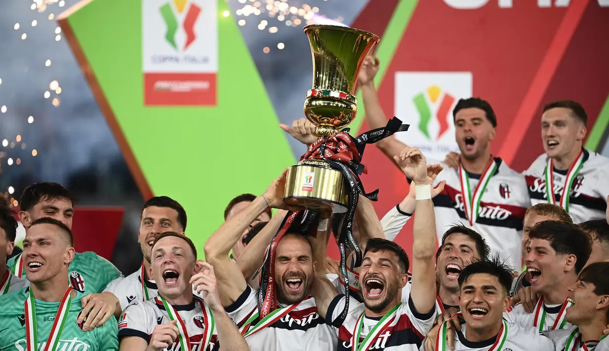 Pemain Bologna merayakan kemenangan dengan mengangkat trofi Piala Italia (Coppa Italia) usai mengalahkan AC Milan pada laga final yang digelar di stadion Olimpico, Roma, pada 14 Mei 2025 waktu setempat atau pada Kamis (15/5/2025) dini hari WIB. (Isabella BONOTTO/AFP)