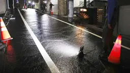Sebuah jalan terendam air setelah gempa bumi di daerah perumahan di Tokyo, Jumat (8/10/2021) pagi. Gempa kuat mengguncang daerah Tokyo pada Kamis malam, menghentikan perjalanan kereta api dan kereta bawah tanah. (Kyodo News via AP)