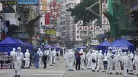 Penyelidik pemerintah yang mengenakan pakaian pelindung berkumpul di daerah Yau Ma Tei di Hong Kong, Sabtu (23/1/2021). Ribuan warga Hong Kong diperintahkan tetap tinggal di rumah setelah otoritas setempat memberlakukan penguncian ( lockdown ) untuk pertama kalinya sejak pandemi COVID-19 merebak. (A