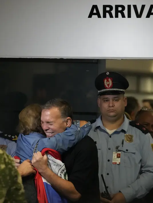 Napout yang berusia 65 tahun, bersama istrinya, membawa bendera Paraguay di Bandara Silvio Pettirossi di ibu kota Asuncion. (AP Photo/Jorge Saenz)