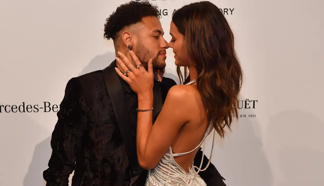 Pemain Paris Saint-Germain (PSG), Neymar dan kekasihnya yang juga model, Bruna Marquesine saling menatap mesra saat menghadiri The Foundation for AIDS Research (amfAR) Gala di Sao Paulo, Brasil, Jumat (13/4). (NELSON ALMEIDA/AFP)