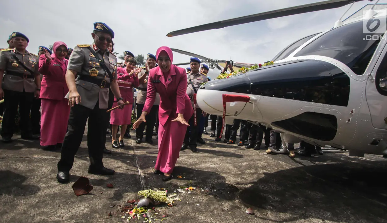 Kapolri Jenderal Tito Karnavian  dan Istri Tri Suswati memecahkan kendi saat menyerahkan dua helikopter jenis Bell 429 IGW dari PT Multi Pasific California usai menghadiri  HUT Korpolairud ke-67, Tangerang, Selasa (5/11). (Liputan6.com/Faizal Fanani)