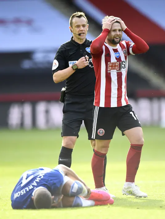 Pemain Sheffield United Oliver Norwood (kanan) mendapat kartu kuning dari wasit Stuart Attwell (tengah) usai melanggar pemain Everton Richarlison pada pertandingan Premier League di Bramall Lane, Sheffield, Inggris, Senin (20/7/2020). Everton menang 1-0. (AP Photo/Peter Powell, Pool)