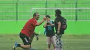 Pelatih Arema Cronus, Milomir Seslija, tampak asyik mengajak buah hati Hamka Hamzah yang bernama Gava dan Gwen bermain saat sela-sela latihan di Stadion Gajayana, Malang, Sabtu (4/6/2016). (Bola.com/Iwan Setiawan)