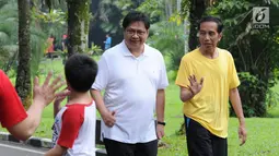 Presiden Joko Widodo atau Jokowi (kanan) dan Menteri Perindustrian Airlangga Hartarto menyapa warga saat olahraga bersama di sekitar Istana Bogor, Sabtu (24/3). Cuaca Bogor sedikit mendung saat keduanya berolahraga. (Liputan6.com/Pool/Biro Pers Setpres)