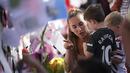 Seorang ibu mengajari anaknya untuk menempelkan pesan saat mengikuti aksi antirasisme di depan mural Marcus Rashford di Withingston, Manchester. (Foto:AP/Jon Super)