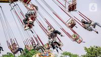 Para pengunjung menaiki wahana bermain di Dunia Fantasi, Ancol, Jakarta, Minggu (10/10/2021). Pelonggaran PPKM level 3 di Jakarta membuat sejumlah tempat wisata kembali ramai didatangi pengunjung. (Liputan6.com/Faizal Fanani)