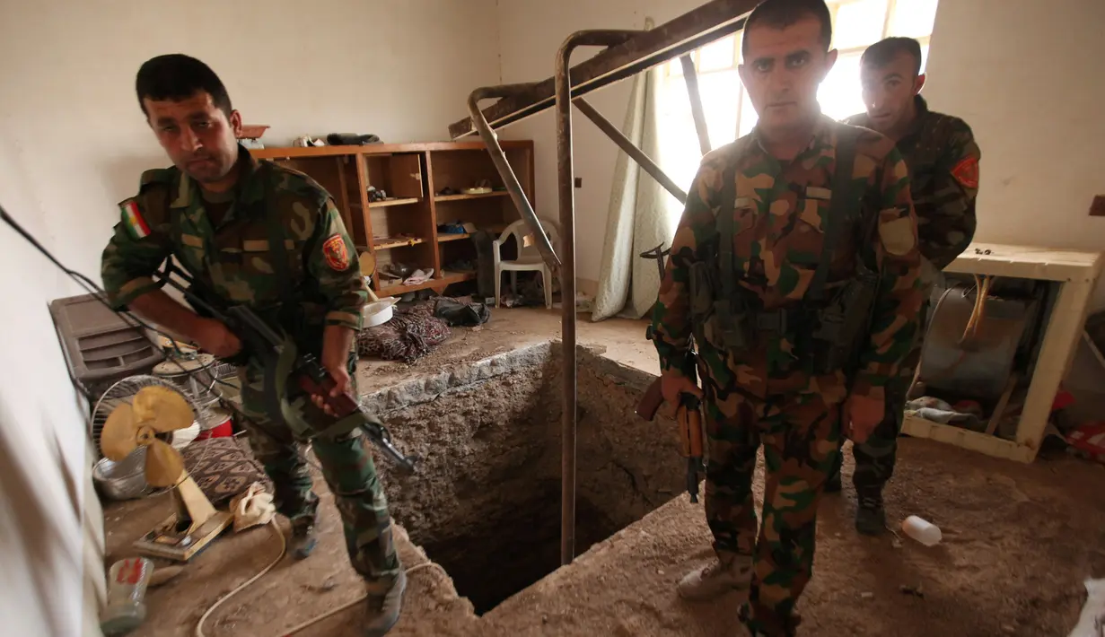 Tiga pasukan Peshmerga bersenjata berjaga di terowongan tempat persembunyian militan ISIS selama operasi penyerangan di Mosul, Irak (19/10). Penemuan terowongan milik militan ISIS itu terdapat di dalam bangunan. (REUTERS/Azad Lashkari)
