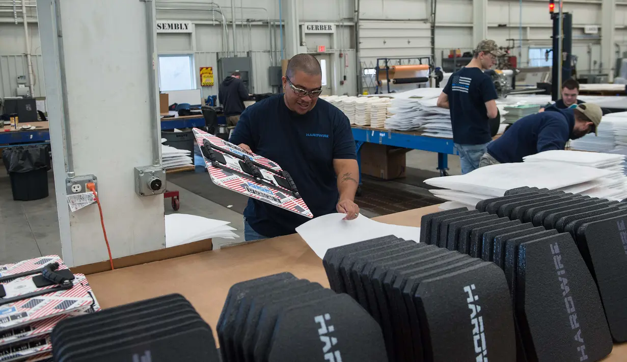 Pekerja mengemasi papan tulis antipeluru di pabrik Hardwire Pocomoke City, Maryland (1/3). Hardwire membuat papan tulis antipeluru untuk ruang kelas yang bisa dimasukan ke dalam tas ransel. (AFP PHOTO / Nicholas Kamm)