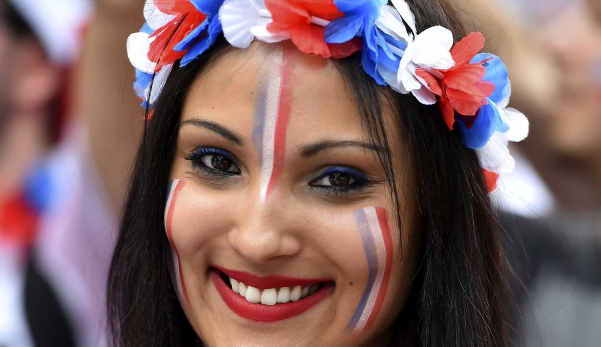 Fans cantik dengan wajah penuh corak bendera Prancis hadir memberikan semangat kepada timnya diareal fan zone pada laga piala Eropa 2016  saat Prancis melawan Jerman di Toulouse , (7/7/2016). (AFP/RÈmy Gabalda)