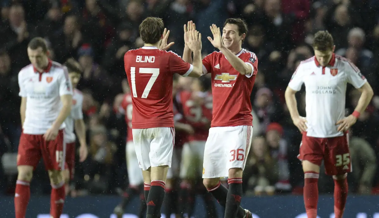 Manchester United, Matteo Darmian (2kanan) dan Daley Blind merayakan kemenangan atas Sheffield United pada laga Piala FA di Old Trafford, Minggu (10/1/2016) dini hari WIB. (AFP Photo/Oli Scarff)
