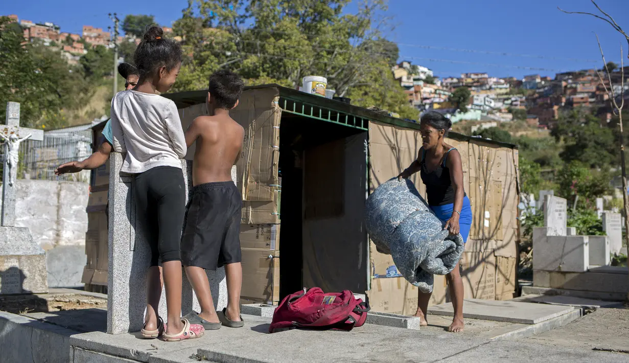 Seorang perempuan membawa kasur ke dalam tempat perlindungan darurat di Pemakaman Umum Selatan di Caracas, pada 10 Februari 2021. Makam yang dirusak telah menjadi rumah bagi banyak tunawisma di Venezuela. (Pedro Rances Mattey / AFP)