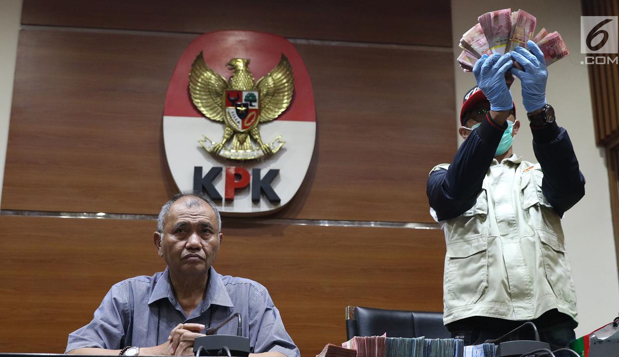 Petugas KPK menunjukkan barang bukti hasil OTT terhadap Bupati Pakpak Bharat Sumatera Utara, Remigo Yolanda Berutu di Gedung KPK, Jakarta, Minggu (18/11). KPK menetapkan tiga tersangka dan menyita uang Rp 150 juta. (Liputan6.com/Helmi Fithriansyah)